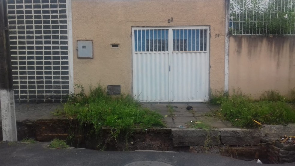 Buraco abre na calçada de uma casa e poste ameaça cair no Pinheiro, em Maceió — Foto: Magda Ataíde/G1
