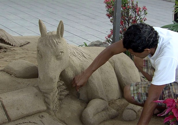 Artista trabalha em presépio feito de areia em Santos, SP (Foto: Reprodução/TV Tribuna)