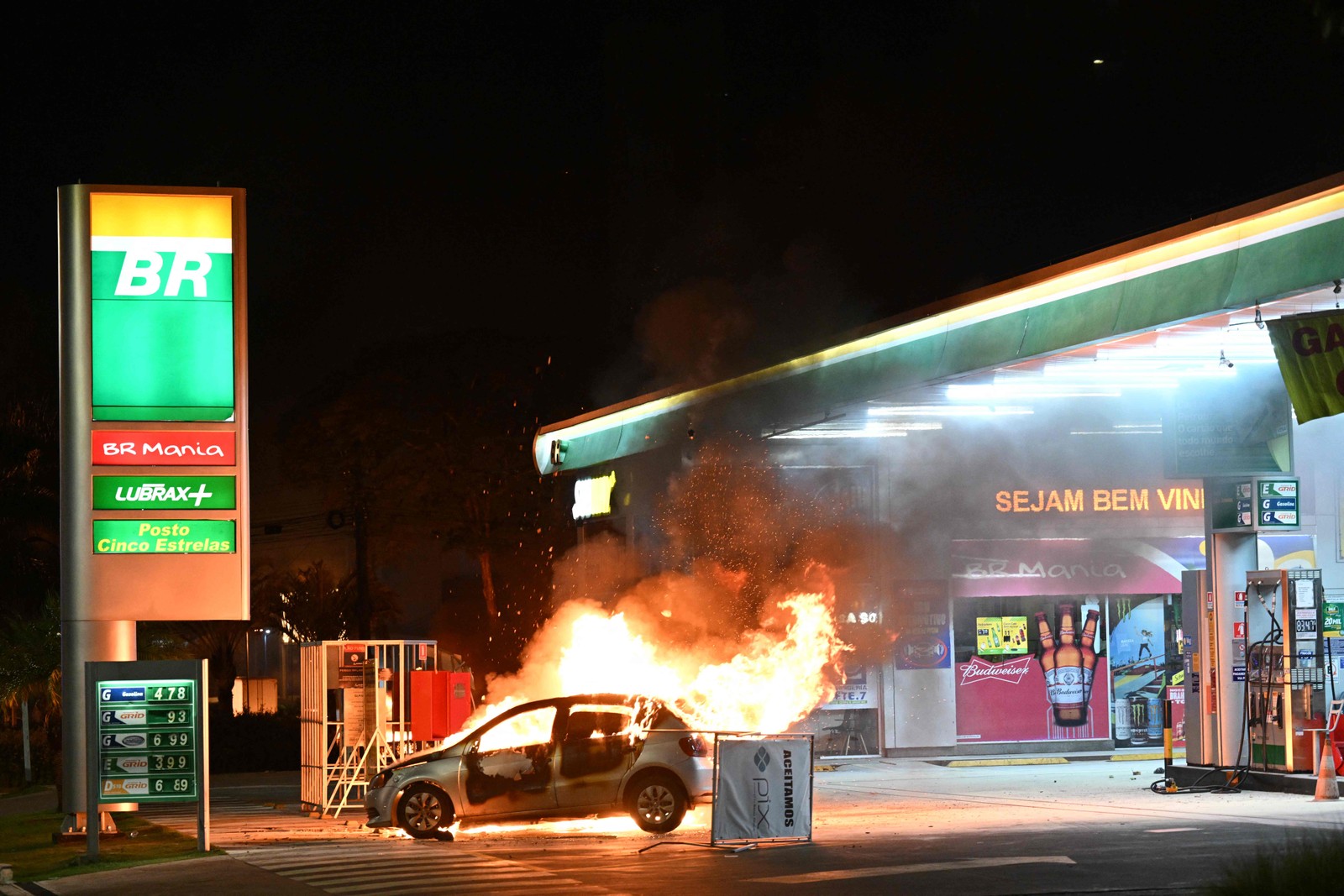 Carro foi incendiado próximo a posto de gasolina — Foto: Evaristo Sá/AFP