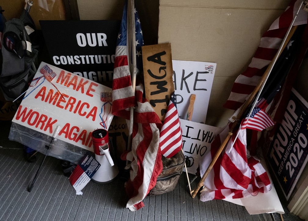 Bandeiras dos EUA e placas pedindo pela volta ao trabalho no Capitólio do Michigan nesta quinta-feira (30) — Foto: Seth Herald/Reuters