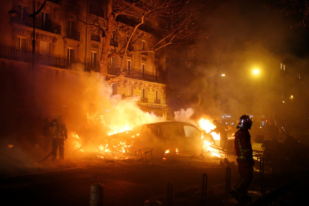 Bombeiros tentam apagar fogo em carro após manifestação dos coletes-amarelos em Paris — Foto: REUTERS/Stephane Mahe