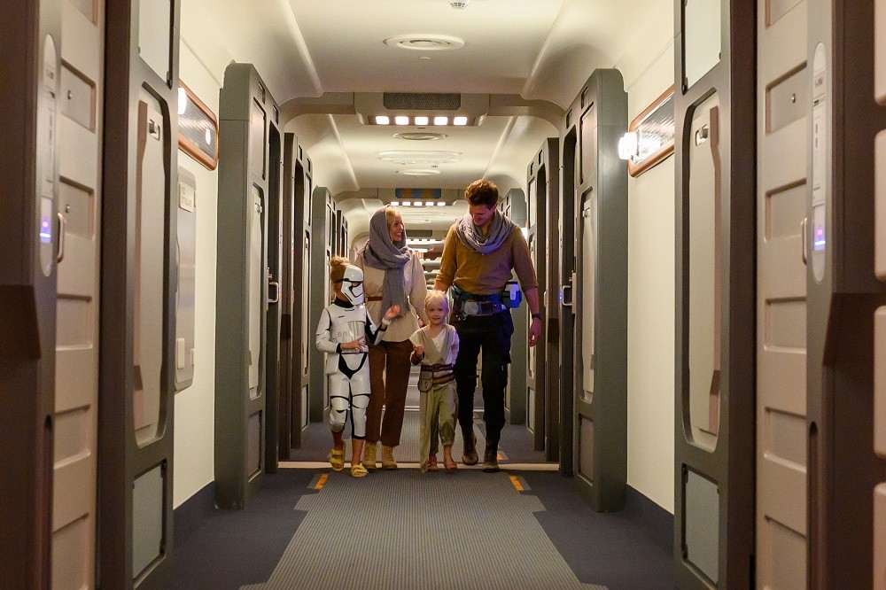 Hailey and Bradley Devine com suas filhas Lucey, de 7 anos, and Greta, de 5, num corredor perto de sua cabine no Star Wars: Galactic Starcruiser, o novo hotel-atração do Walt Disney World, em OrlandoThe New York Times