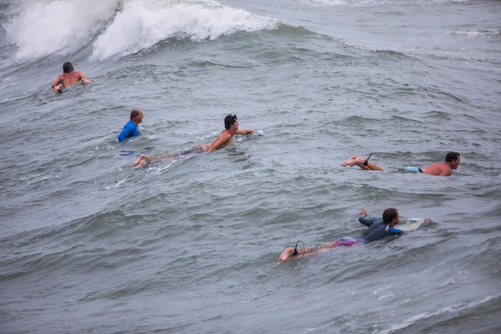 Surfistas entram no mar à espera de grandes ondas provocadas pela aproximação do furacão Isaías em Emerald Isle, na Carolina do Norte, na segunda-feira (3)  — Foto: Julia Wall / The News & Observer via AP