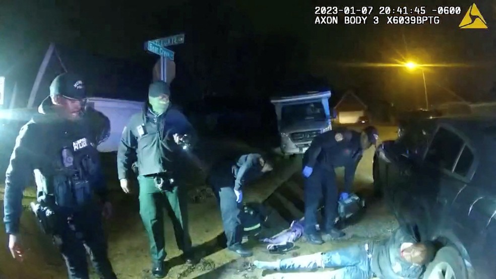 Imagem de policiais com Tyre Nichols, encostado na roda do carro — Foto: Reprodução/Polícia de Memphis