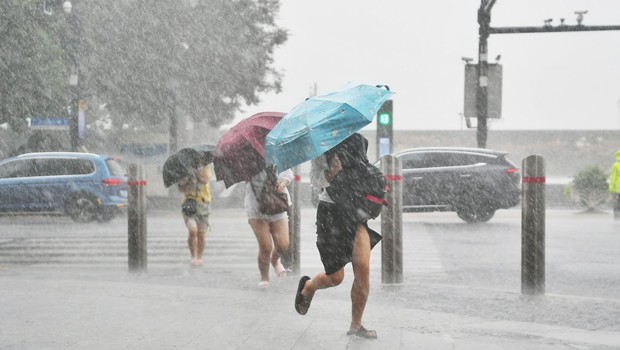 Cidadãos com guarda-chuvas caminham na chuva trazida pelo tufão Chanthu em Xangai, China (Foto: VCG/VCG via Getty Images)