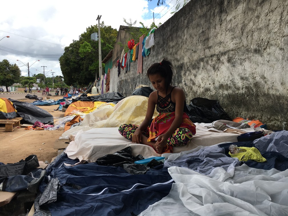 Jorgelis Vasquéz, 20, vive em frente ao abrigo São Vicente há 1 mês  à espera de vaga (Foto: Emily Costa/G1 RR)