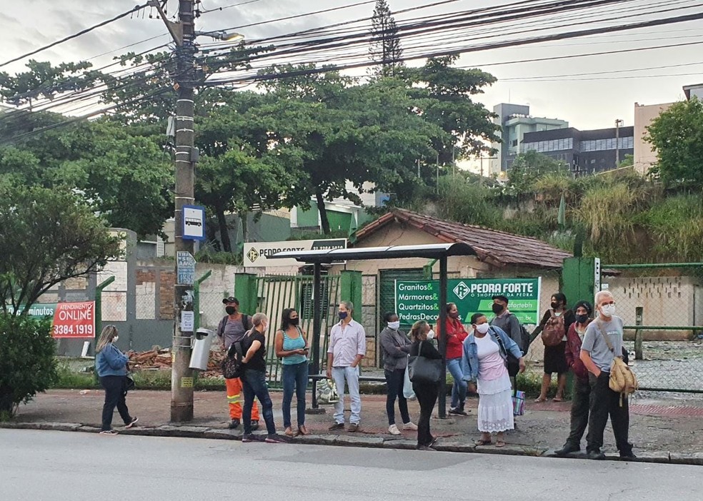 Passageiros aguardam pela chegada do transporte em ponto do Barreiro — Foto: Camila Falabela/TV Globo