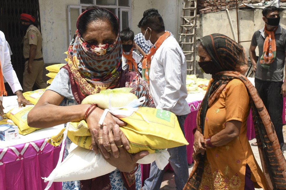 Indiana carrega sacos de alimentos distribuídos em Amritsar, na Índia — Foto: Narinder Nanu/AFP