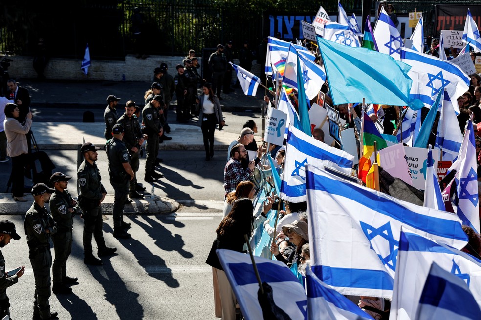 Civis seguram bandeiras de Israel durante protesto nas ruas de Jerusalem — Foto: Ammar Awad/REUTERS