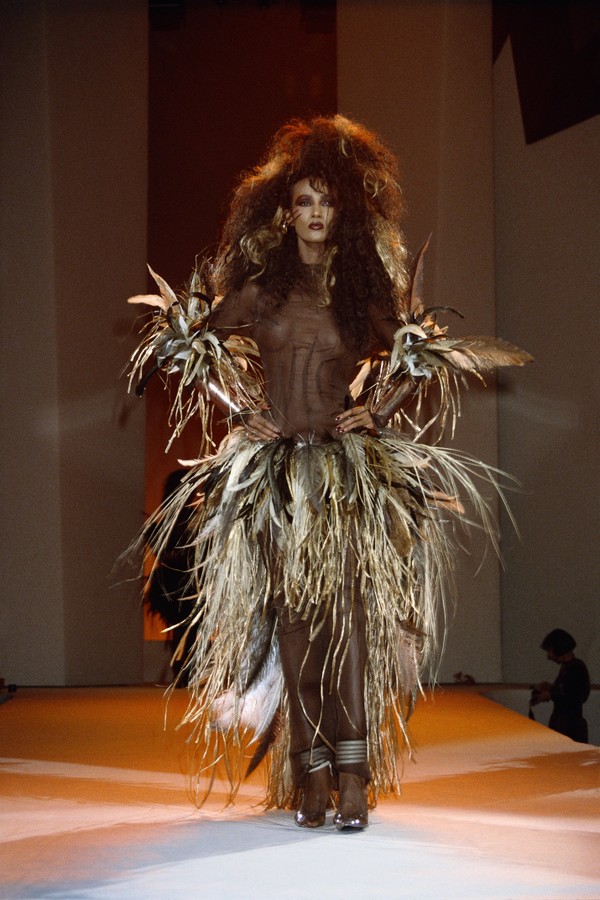 Fashion model Iman wears a feathered dress with sheer bodice by German fashion designer Thierry Mugler at his spring-summer 1988 fashion show in Paris. Mugler presented his women's ready-to-wear collection at the show. (Photo by Pierre Vauthey/Sygma/Sygma (Foto: Sygma via Getty Images)