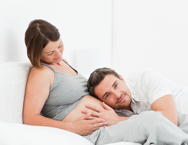 Pai sente a barriga da grávida (Foto: Thinkstock)