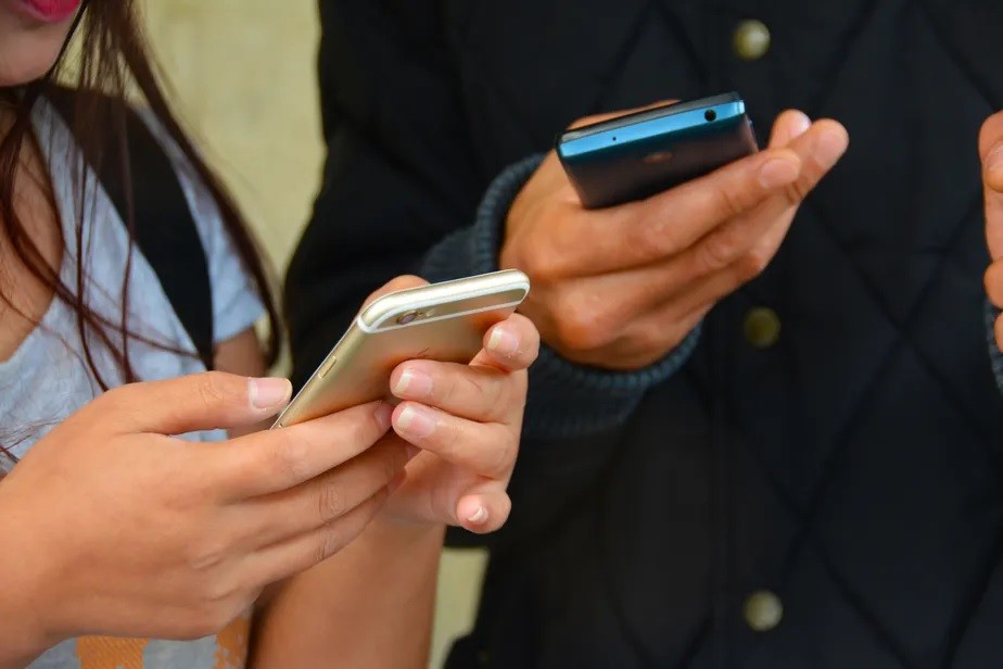 Adolescentes empunham smartphones. Segundo especialistas, acesso a discurso de ódio hoje é facilitado pelas redes sociais