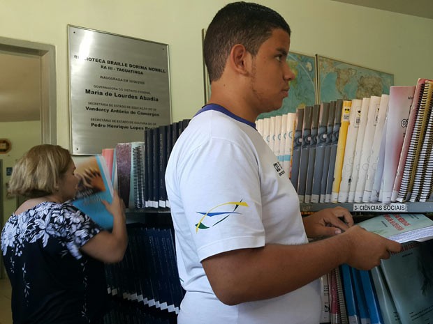 Deficientes visuais buscam livros em estante da biblioteca (Foto: Raquel Morais/G1)