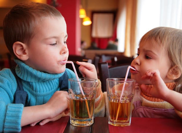 Crianças bebendo refrigerante em um restaurante (Foto: Shutterstock)
