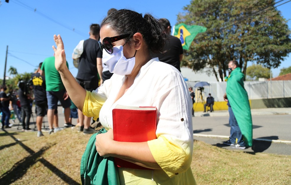 Uma das pessoas se ajoelha e reza em frente à PF, em Curitiba — Foto: Giuliano Gomes/PR Press