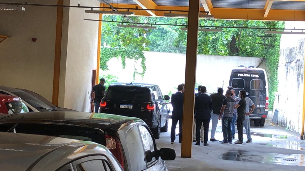 Gerson, à esquerda do carro, chega à delegacia para depor — Foto: Caíque Andrade