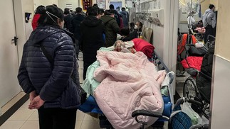 Paciente aguarda no corredor de hospital em Pequim — Foto: Jade Gao/AFP