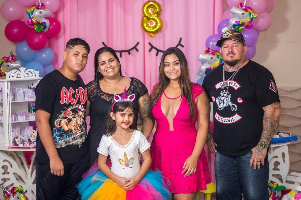 Na foto: tatuador, esposa (de vestido preto), filhos dela e, à frente, a filha do casal  — Foto: Arquivo Pessoal