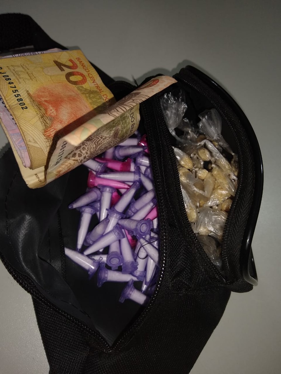 Com ele foram achadas porções de cocaína, crack e também dinheiro — Foto: Polícia Militar/Divulgação