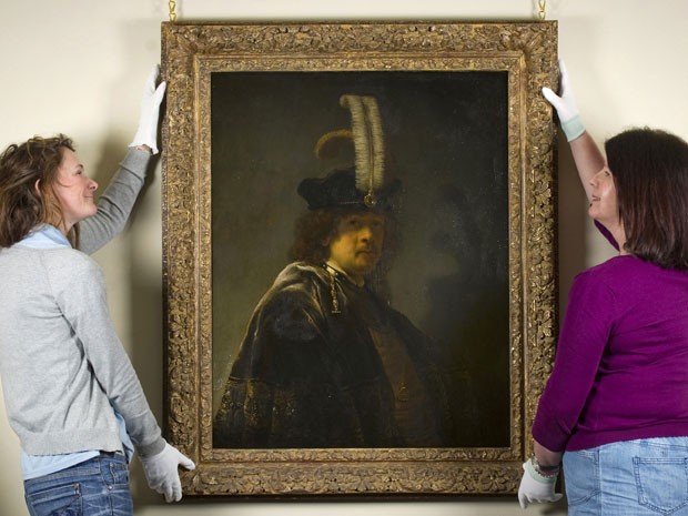 Funcionárias da fundação britânica The National Trust mostram autorretratao de Rembrandt autenticado pela instituição; análises acreditavam que a obra tinha sido pintada por um aluno do mestre holandês (Foto: AFP)