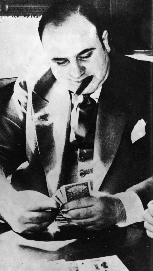 American gangster Al Capone ('Scarface') (1899 - 1947) plays cards in a train compartment during his transport to prison to serve a sentance for tax evasion, October 1931. (Photo by Hulton Archive/Getty Images) (Foto: Getty Images)