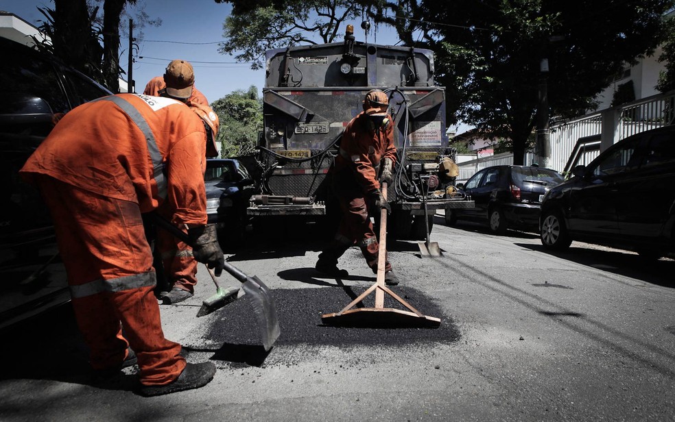 Equipe da Prefeitura de São Paulo tapa buraco de uma rua (Foto: Caio Kenji/G1)
