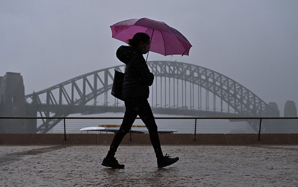 Mulher é vista em frente a Sydney Harbour Bridge, na Austrália, em foto de 10 de outubro — Foto: Steven Saphore/AFP