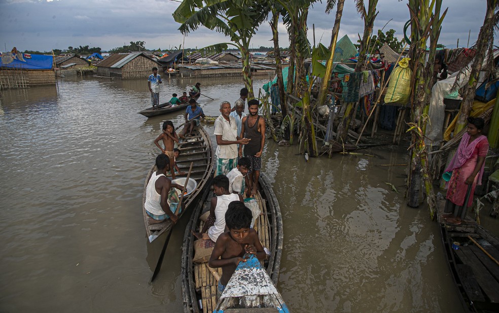 Indianos se abrigam em barcos ao longo das casas submersas pelo transbordamento do rio Brahmaputra, em Assam, no dia 16 de julho. Milhares estão desabrigados pelas inundações na região — Foto: Anupam Nath/AP