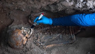 Homem trabalha nos restos de um dos 42 corpos humanos encontrados enterrados no antigo hospital San Andrés, em Lima. Arqueólogos peruanos encontraram cripta em antigo hospital construído em 1552, no centro histórico da capital — Foto: ERNESTO BENAVIDES / AFP