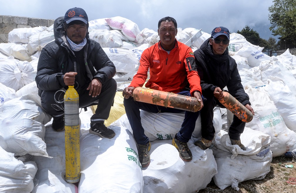 Alpinistas nepaleses posam para foto depois de coletar lixo do monte Everest no dia 27 de maio. O objetivo do governo nepalês é trazer de volta 10 toneladas de lixo da montanha. — Foto: Prakash Mathema/AFP