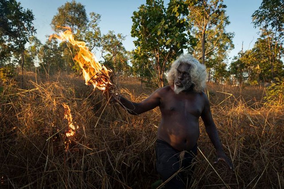 O cacique de Nawarddeken, Conrad Maralngurra, queima grama para proteger a comunidade de Mamadawerre dos 'incêndios florestais' do final da temporada, em Mamadawerre, Arnhem Land, Austrália, em 3 de maio de 2021 — Foto: Matthew Abbott para National Geographic