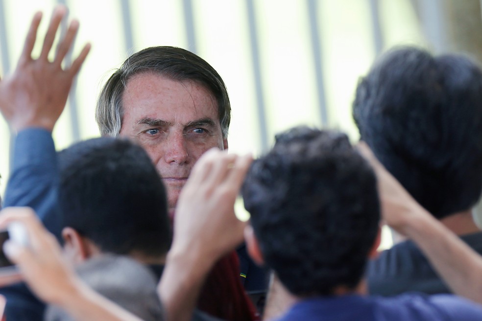 Bolsonaro observa apoiadores na sa&iacute;da do Pal&aacute;cio do Alvorada &mdash; Foto: REUTERS/Adriano Machado