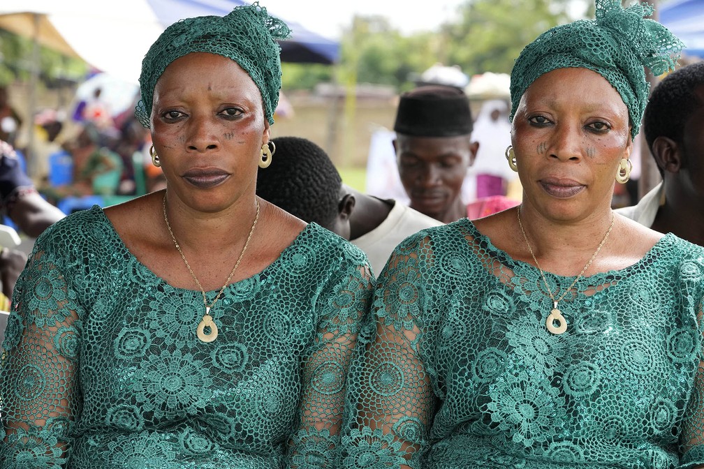 Taiwo Adebowale e Kehinde Adebowale, de 47 anos, participantes do 12º festival de gêmeos de Igbo-Ora. A cidade no sudoeste da Nigéria celebra anualmente a alta incidência de gêmeos entre seus habitantes — Foto: Sunday Alamba/AP