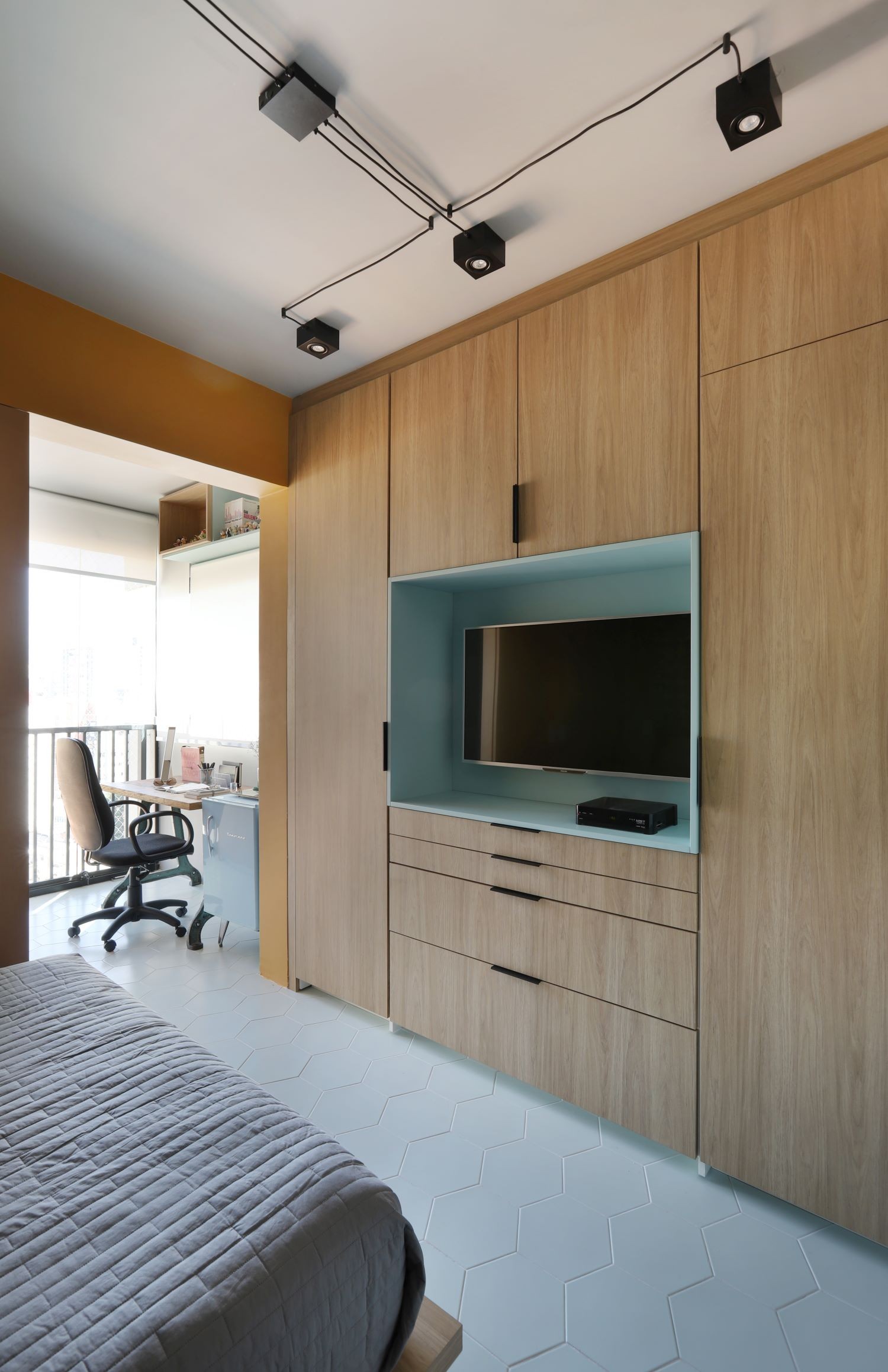 QUARTO/HOME OFFICE | O painel atrás da cama traz mais cores, que se misturam com o verde da parede (Foto: Divulgação / Mariana Orsi)