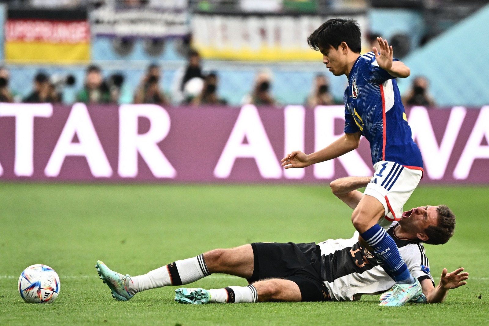 O atacante Thomas Mueller e o meio-campista do Japão Takefusa Kubo lutam pela bola — Foto: Jewel SAMAD / AFP