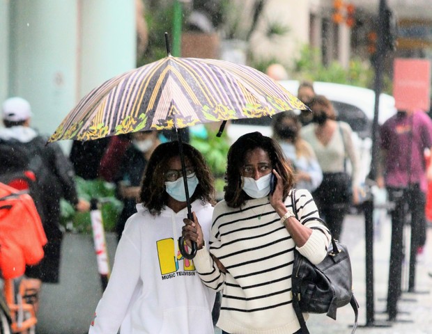Gloria Maria e filha encaram chuva após compras no Rio de Janeiro (Foto: Daniel Delmiro/AgNews )