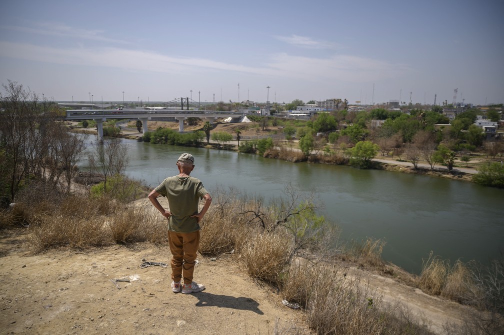 Homem no lado americano da fronteira EUA e México observa o Rio Grande, que divide os países, em Roma (Texas), em foto de 27 de março — Foto: Ed Jones/AFP