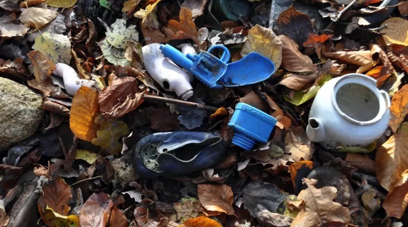 Armas de brinquedo foram encontradas nas pilhas de lixo. O recipiente de plástico quadrado, que parece ser um frasco de tinta, possui texto em cirílico em alto-relevo (Foto: GRZEGORZ KIARSZYS via BBC News)