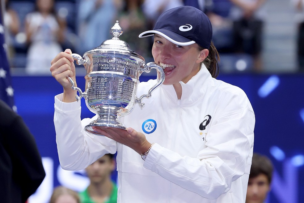 Iga Swiatek morde o troféu de campeã da US Open — Foto: Matthew Stockman/Getty Images