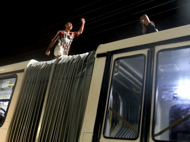 Jovens se arriscam em teto de ônibus articulado, em avenida de Manaus (Foto: Jamile Alves/G1 AM)