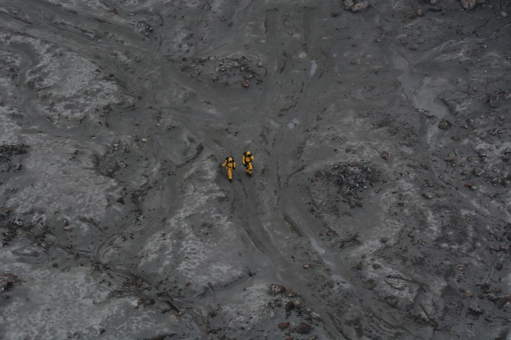 13 de dezembro - Membros da equipe de resgate caminham com trajes protetores especiais durante as buscas por corpos de vítimas da erupção do vulcão da Ilha Branca, na Nova Zelândia — Foto: New Zealand Defence Force via Reuters