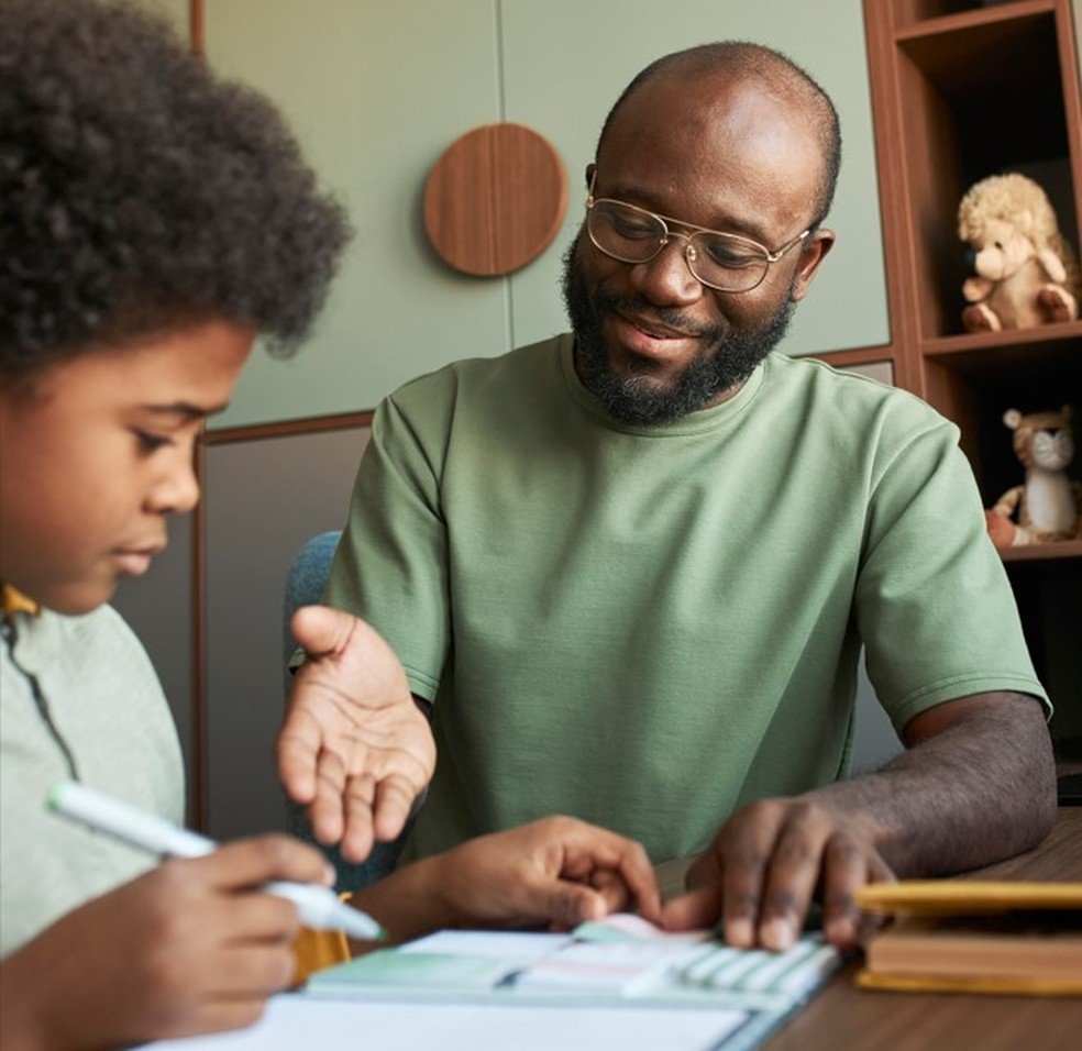 Pai ajuda filho a fazer atividades da escola — Foto: Imagem de Freepik