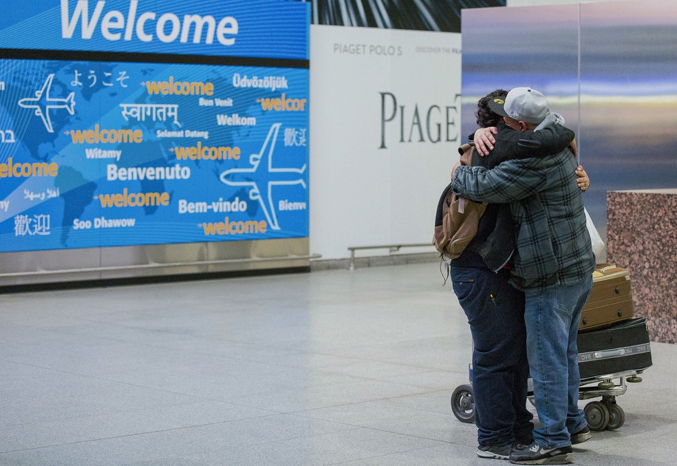 Foto de fevereiro de 2017 mostra encontro entre pai e filho no aeroporto de Nova York. O jovem iemenita, de 13 anos, quase foi impedido de entrar nos EUA por conta de decreto de Trump (Foto: AP Photo/Alexander F. Yuan, File)