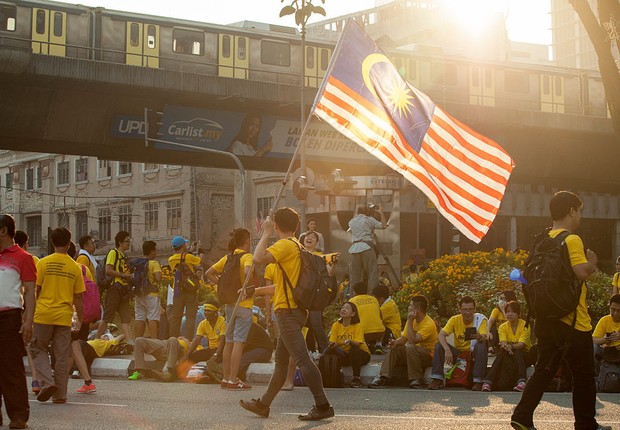 Manifestantes carregam bandeira da Malásia, em protesto na capital do país  (Foto: Charles Pertwee/Getty Images)