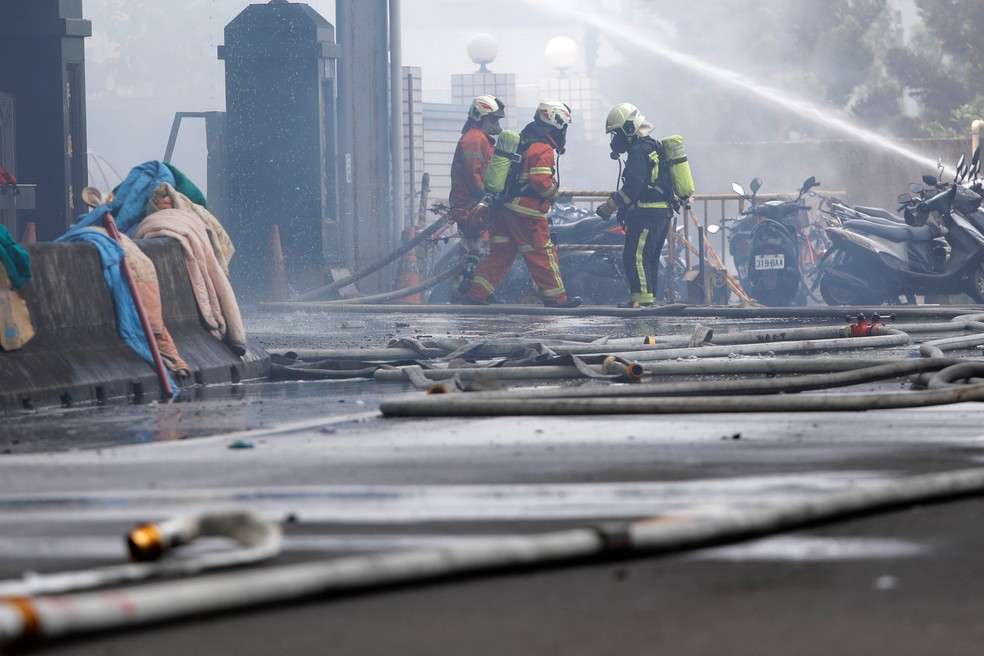 Bombeiros trabalham no combate ao fogo (Foto: Tyrone Siu/Reuters)