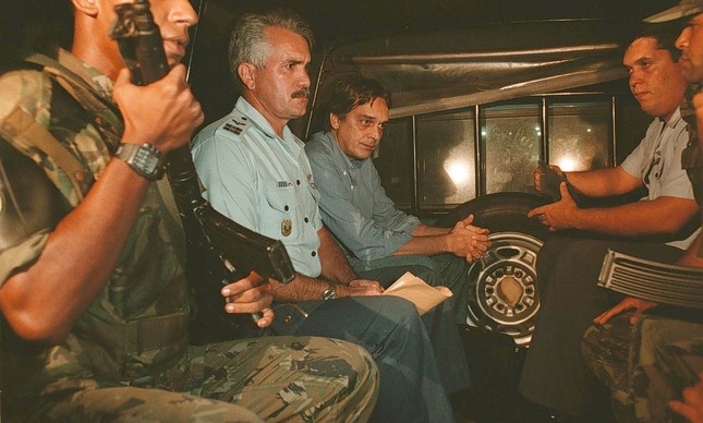 Luiz César Pereira (sem uniforme, no centro) é escoltado para prisão