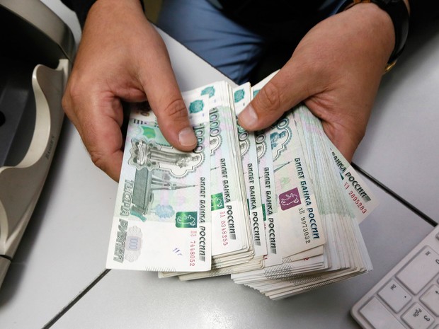 Funcionário conta notas de rublo em um escritório em Krasnoyarsk, na Sibéria (Foto: Ilya Naymushin/Reuters)