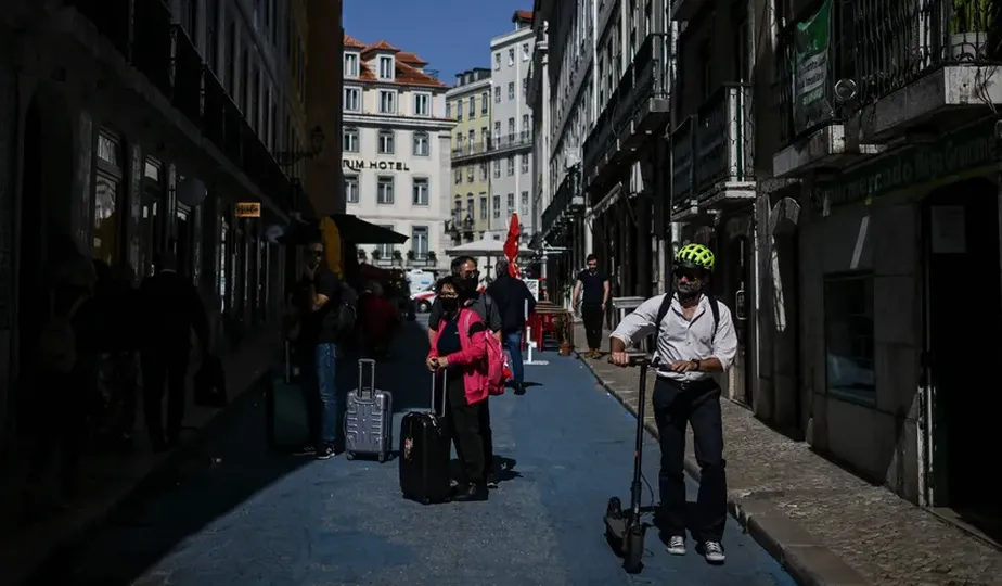 Turistas e residentes em uma rua de Lisboa