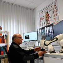 Médico Guenter Steinebach trabalha com o auxílio de um robô — Foto: Christof STACHE / AFP