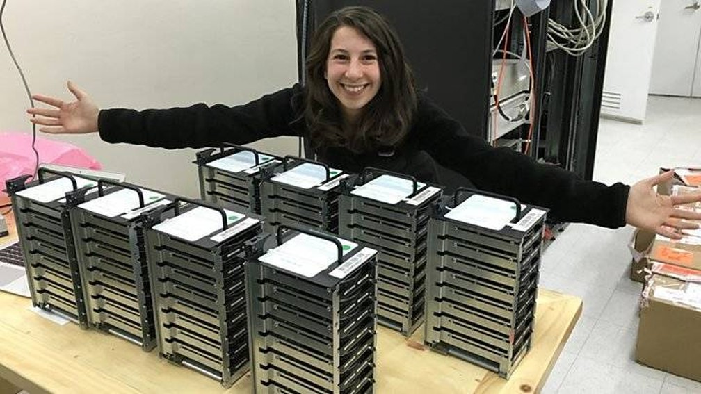 Katie Bouman posa com os HDs que armazenaram as informaÃ§Ãµes que seu algoritmo reconstruiu na primeira imagem jÃ¡ registrada de um buraco negro â€” Foto: DivulgaÃ§Ã£o/HET